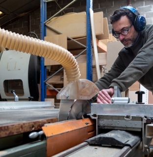 travail bois massif atelier machine découpe artisan menuisier mur briques