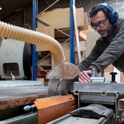 travail bois massif atelier machine découpe artisan menuisier mur briques