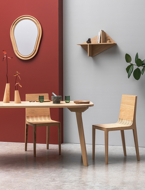 un salon qui mélange minimalisme et couleur avec du mobilier en bois clair et des murs colorés